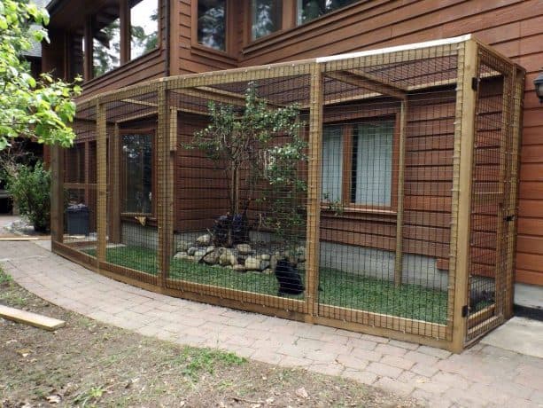 a cat enclosure looks wonderful with its natural feel from the grass flooring and live tree inside it