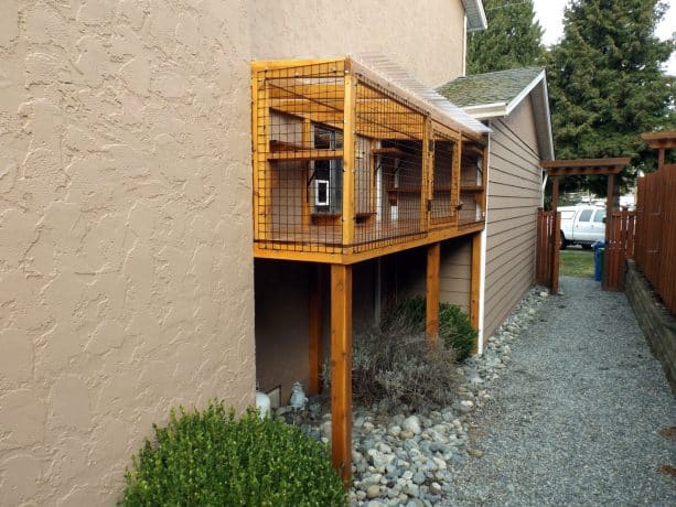 a space-friendly and neat wooden cat enclosure by the window
