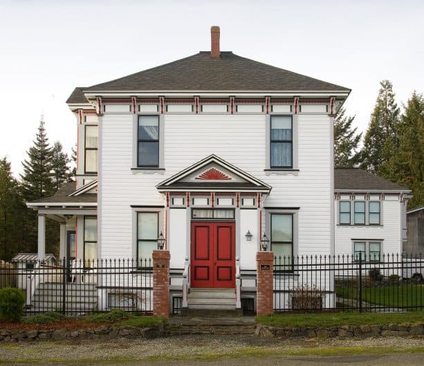 grey trim and red accents decorating a traditional white home exterior