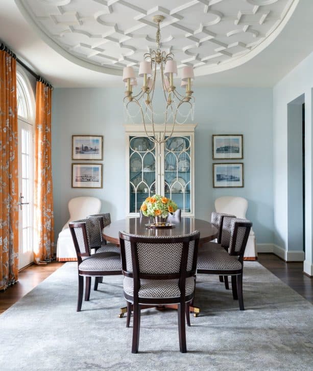 a soothing traditional dining room with soft blue walls and orange floral-patterned curtains