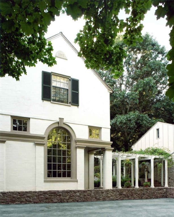 a cream-white house with greige exterior trim around the windows