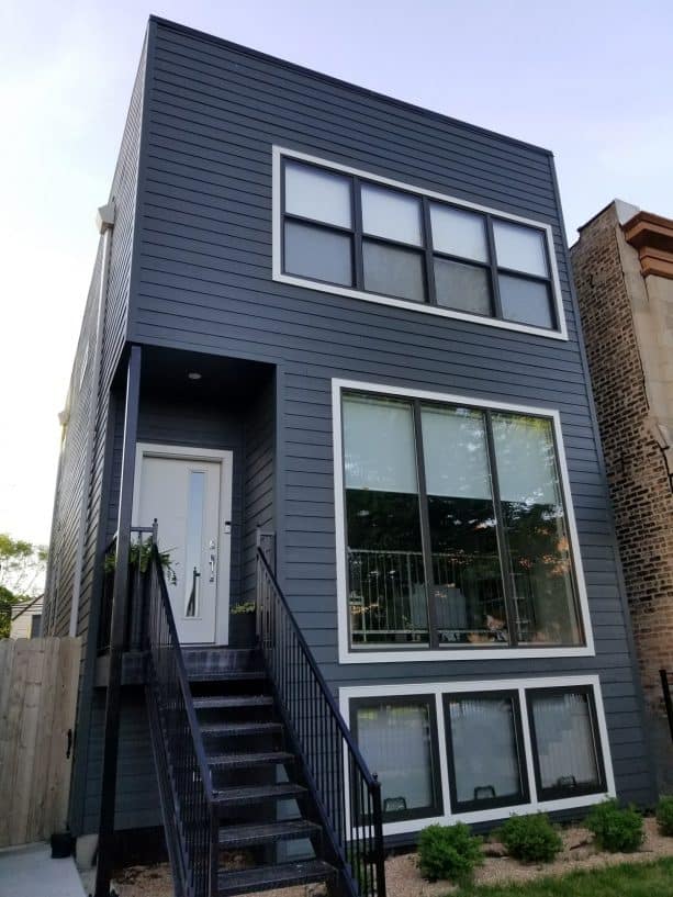 a modern home exterior design with dark grey walls and white trim