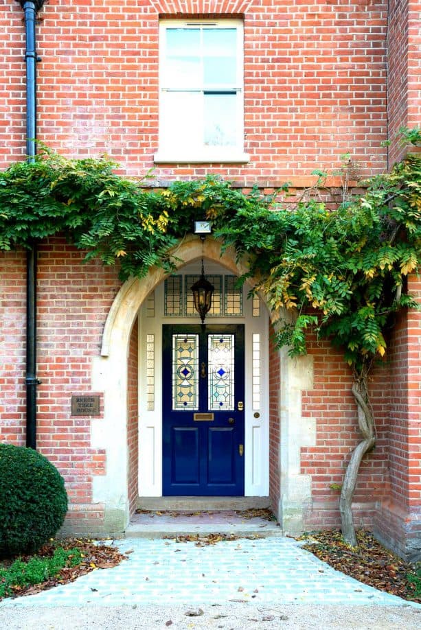 a stunning navy blue door paired with red brick wall