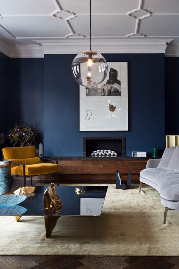 a living room with navy blue wall and wood fireplace hearth