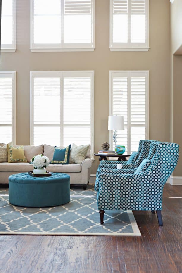 a transitional living room with tan walls and accentuating blue furniture