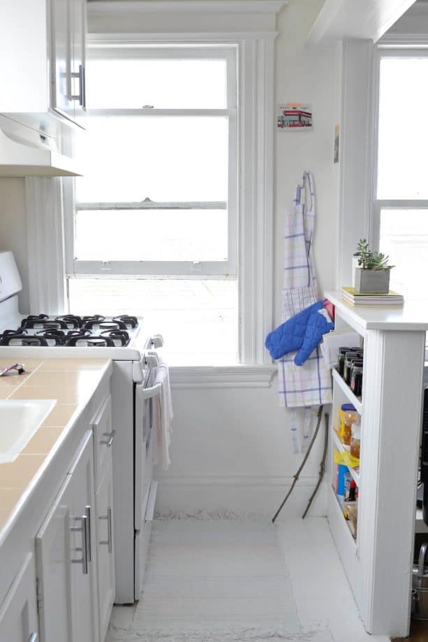 a half wall with built-in shelf in a small eclectic kitchen design