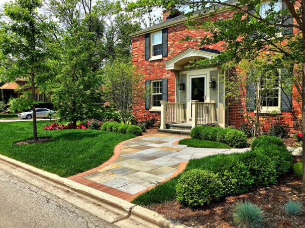 a traditional colonial red brick house with black shutters