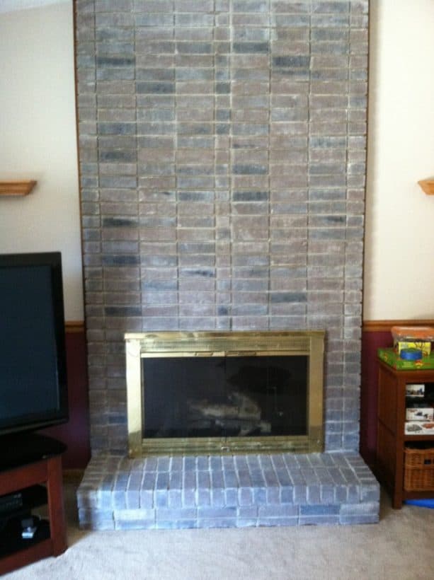 modern fireplace with gray color-washed wall-size brick mantel and support