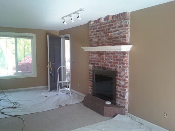 before makeover floor to ceiling red brick fireplace with white mantel shelf