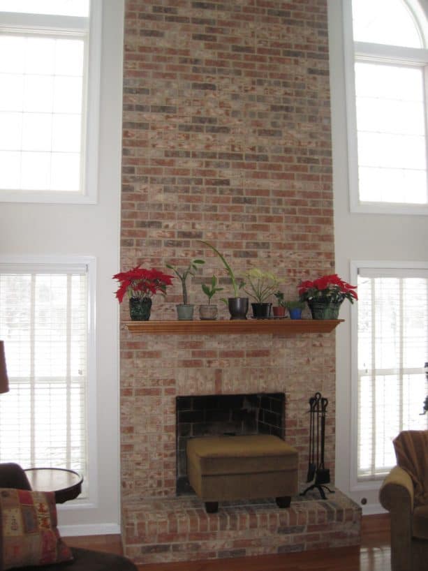 before makeover tall floor to ceiling brick fireplace with raised hearth no insert