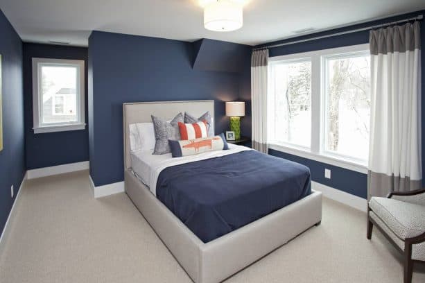 a navy blue bedroom with grey bed