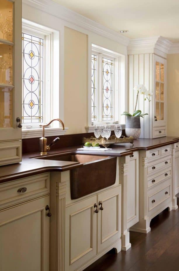 off-white cabinets paired with dark wood countertops and copper sink