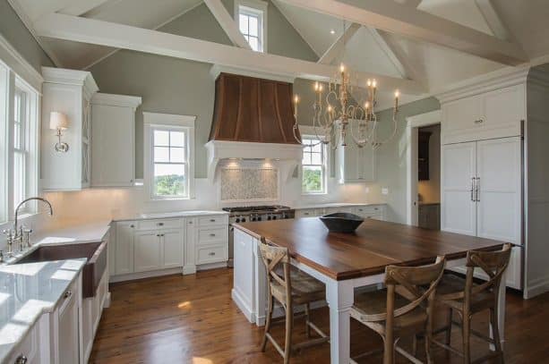 off-white kitchen cabinets paired with copper range hood and sink