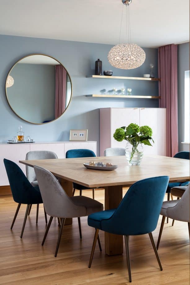 a contemporary dining room with soft blue walls and soft pink full-length curtains)