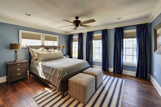 a traditional bedroom with blue walls and navy blue curtains