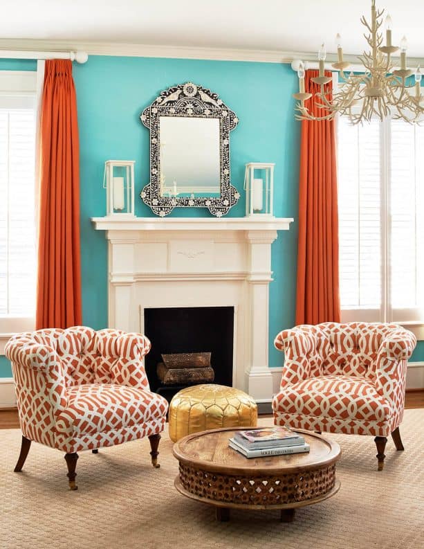 a traditional interior with bright blue walls and orange curtains