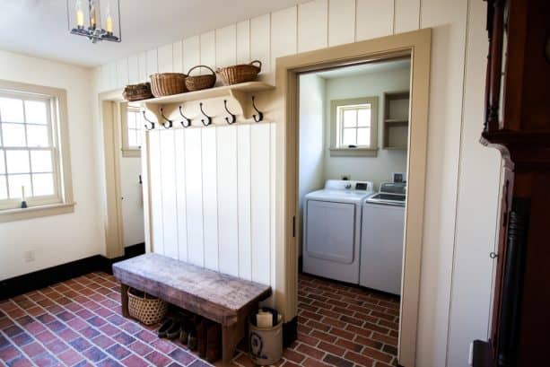 a farmhouse laundry room with brick tile as the floor material