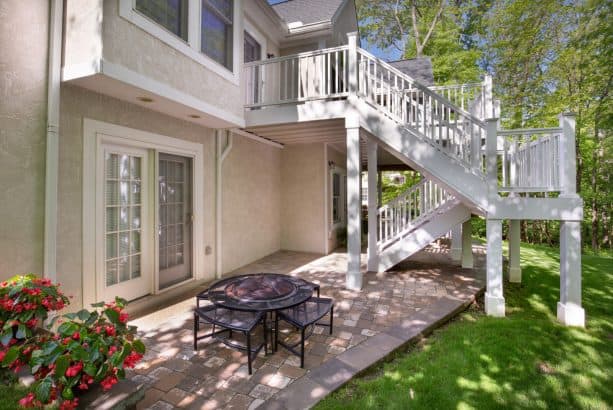 a beach-style walkout basement patio with alternative dining table with grill feature