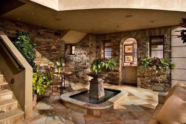 a contemporary walkout basement patio with fountain feature