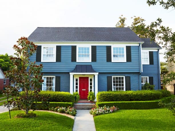 a classic and timeless exterior look with stone blue wall and berry red front door