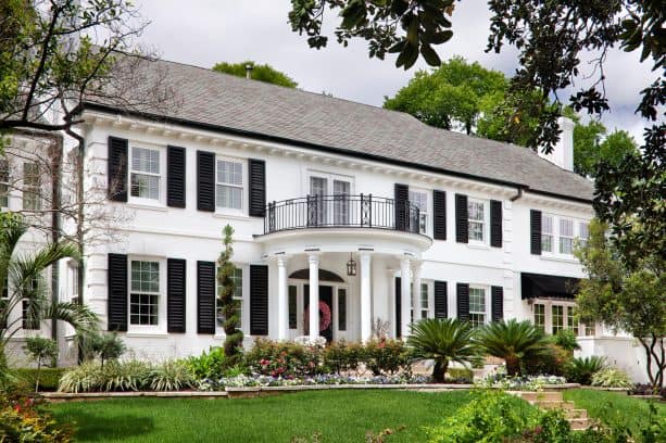 a white house with black shutters and some other black accessories