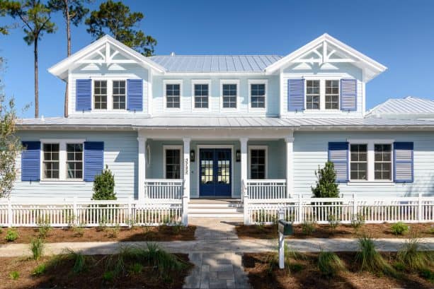 a beach style house with bright blue wall siding and Luxe Blue front door and shutters