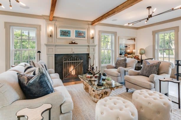 a farmhouse living room with white walls, greige trim, and greige fireplace