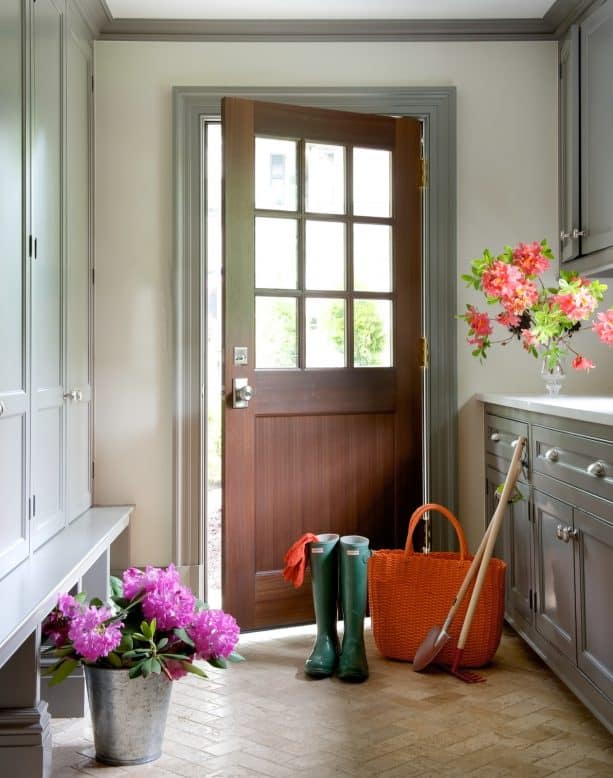 a traditional entry with off-white walls, grey trim, and wood door