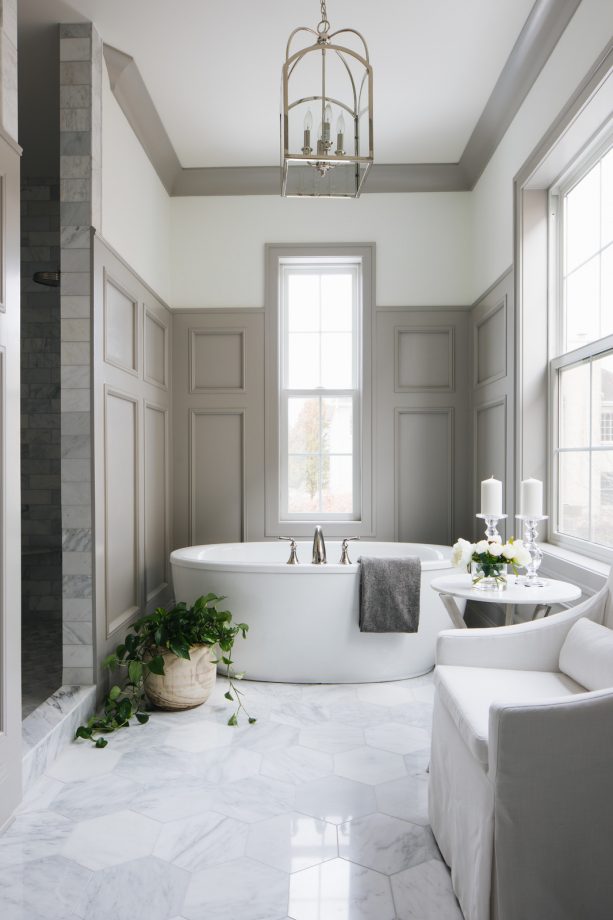 a transitional bathroom with white walls, greige trim, and greige raised-panel wainscoting