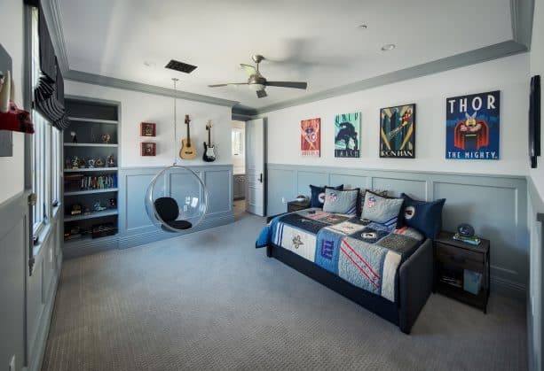 a transitional kid’s bedroom with white walls, grey trim, and grey recessed-panel wainscoting