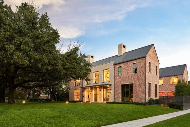 a transitional orange brick house with simple yet stunning charcoal metal roof