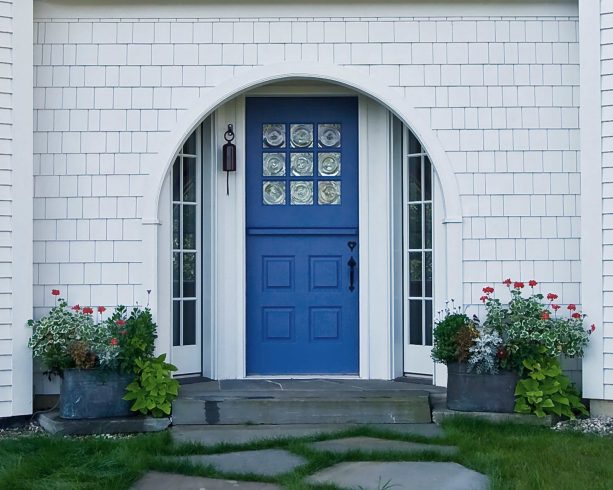 a unique entry design with navy Dutch-style front door