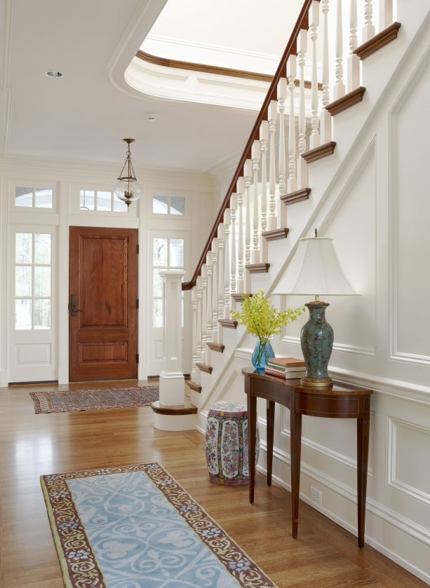 a wood door and white trim that look matching with the staircase design