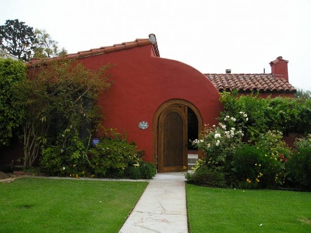 the combination of red stucco and wooden trim for creating a welcoming visual