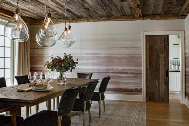 the use of white trim for a wood door in a wood-dominated farmhouse dining room interior