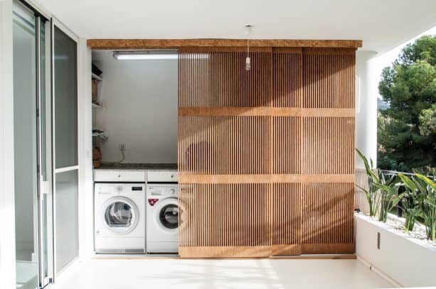 a balcony laundry closet with custom sliding screen doors