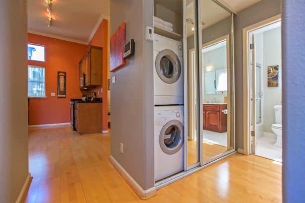 a unique laundry closet with mirrored sliding doors