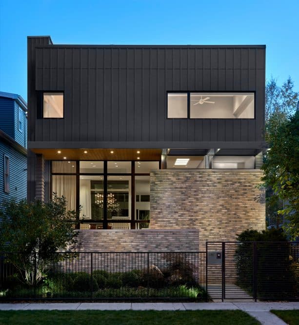 an industrial contemporary living place with half mixed tan brick and half charcoal grey siding