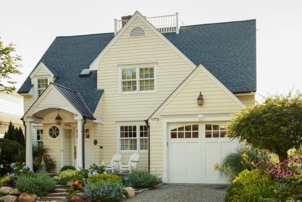 a traditional exterior with buttercream yellow siding, charcoal black roof, and white for the doors, windows, and trim