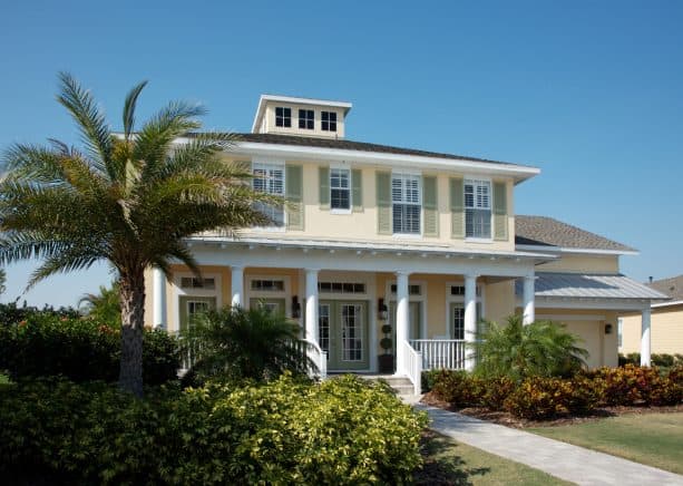 soft yellow, white, and sage green tropical exterior design