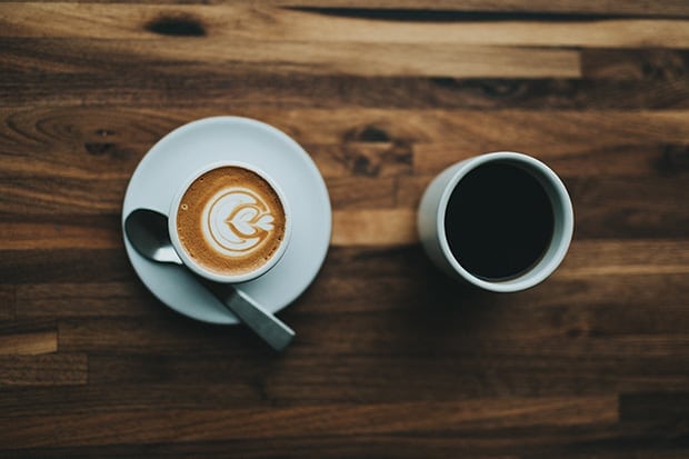 Cappuccino next to a brewed coffee on a table