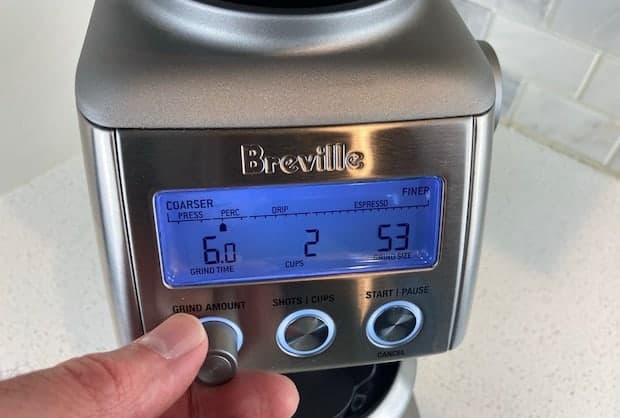 Closeup of the Breville Smart Grinder Pro with a hand on the grind time knob
