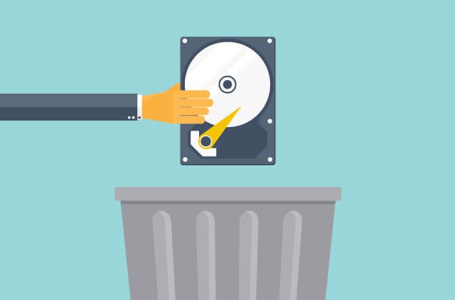 trustedserver Hand holding a hard drive over a trash can.