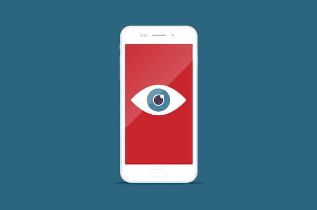 stalkerware-spyware-apps A smartphone screen with an open eye on a red background.