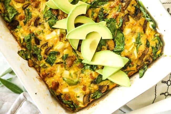 Keto breakfast casserole horizontal image casserole in dish with avocados on top