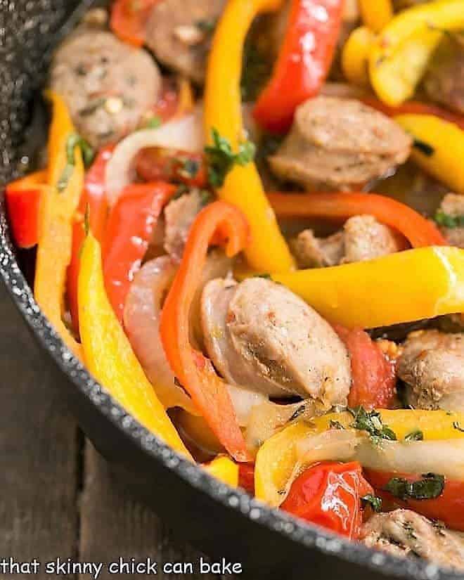 Skillet Italian Sausage and Peppers - a comforting, flavorful meal that's easy to prepare and can be served with Provolone for an unforgettable sandwich! Close view of Italian Sausage and Peppers in a skillet