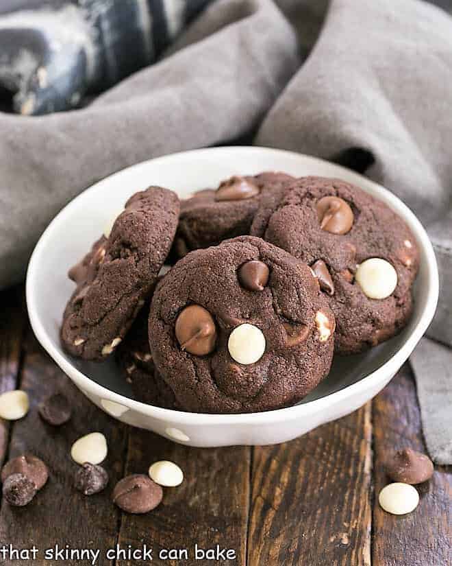 Chewy Quadruple Chocolate Cookies - outrageously delicious and perfect for all the chocoholics in your life! Quadruple Chocolate Cookies in a white bowl surrounded by chocolate chips