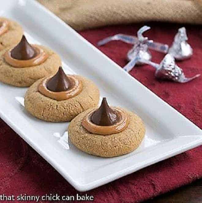 Caramel Biscoff Blossoms - a twist on peanut blossoms for cookie butter and caramel lovers! Caramel Biscoff Blossoms Cookies on a white ceramic tray