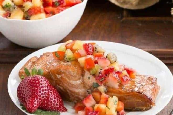Strawberry Salsa Topped Salmon garnished with fresh strawberries on a white plate