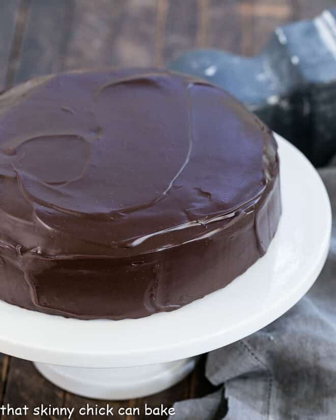 One Layer Fudge Cake - Rich, delectable and perfect when you don't need to feed a crowd! One Layer Fudge Cake on a white ceramic cake stand